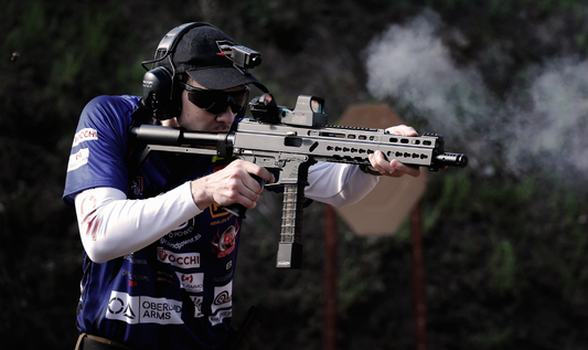 a competitive shooter actively firing a firearm during a shooting event.